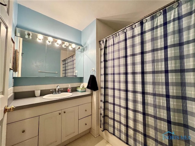 bathroom featuring vanity and backsplash