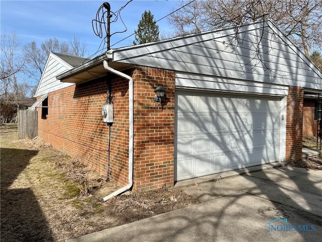 view of side of home with a garage and brick siding