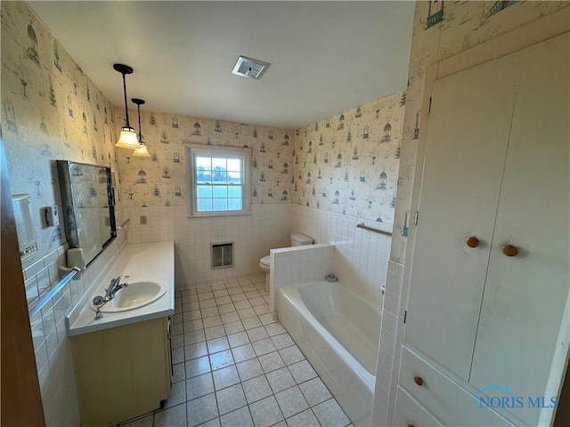 full bathroom with tile patterned floors, toilet, tile walls, wallpapered walls, and vanity