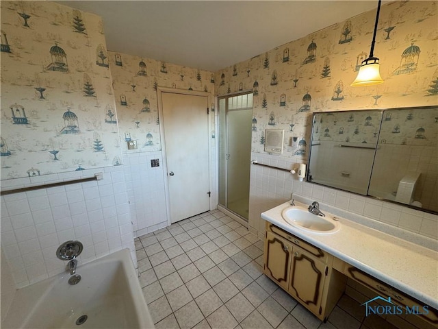 full bath featuring tile walls, a wainscoted wall, wallpapered walls, and vanity