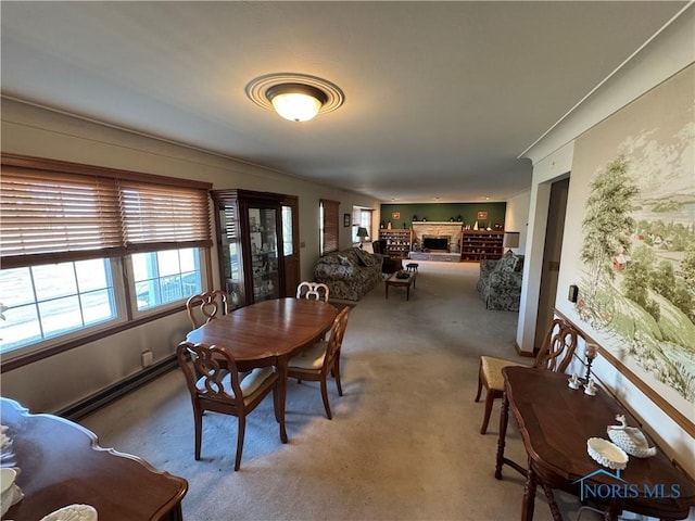 dining area featuring a fireplace, carpet, and a baseboard radiator