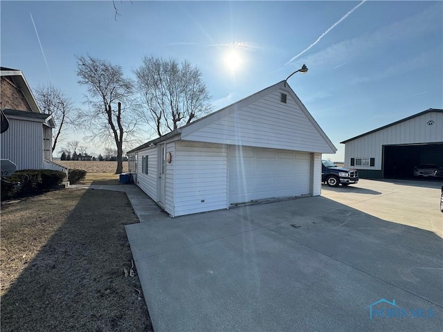 exterior space with a detached garage and an outbuilding