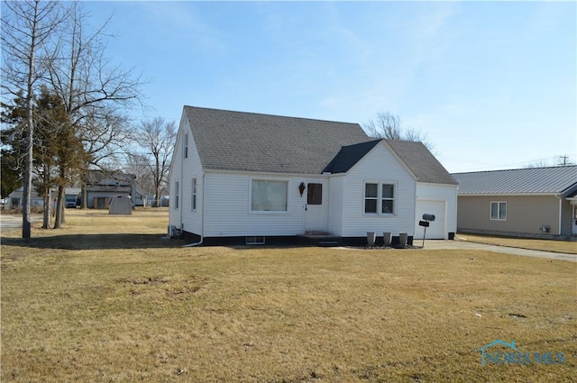 back of house with entry steps, a lawn, a garage, and roof with shingles