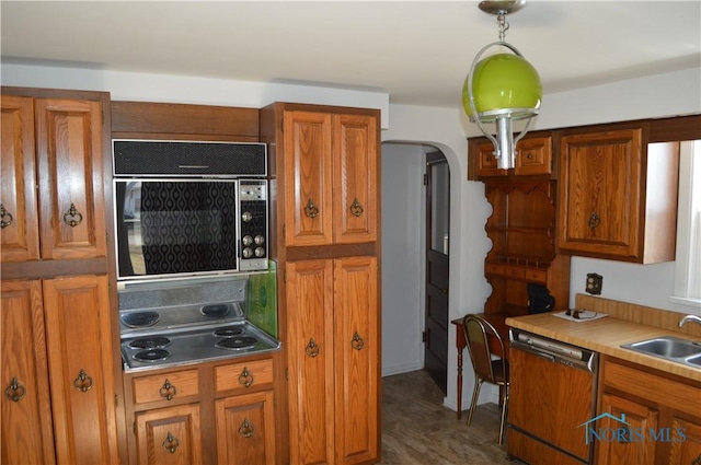 kitchen with a sink, arched walkways, dishwasher, and brown cabinetry