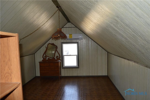 additional living space with wood walls, a wall mounted AC, and lofted ceiling