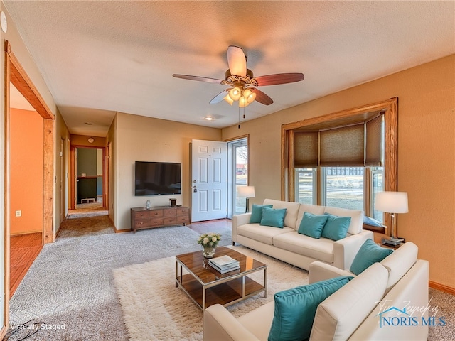 living room with carpet, a ceiling fan, baseboards, and a textured ceiling