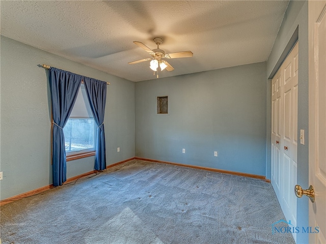 unfurnished bedroom featuring carpet, baseboards, a closet, and a textured ceiling