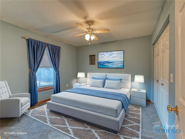 carpeted bedroom with a closet, baseboards, and a textured ceiling