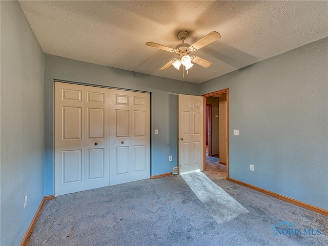 unfurnished bedroom with a closet, baseboards, carpet, and a textured ceiling