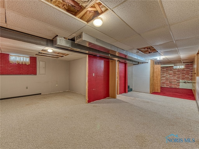 finished basement with a paneled ceiling and carpet