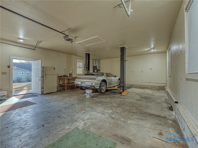 garage with a garage door opener and freestanding refrigerator