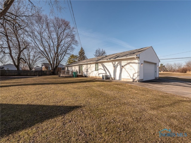 view of property exterior with a yard, fence, a garage, and a wooden deck