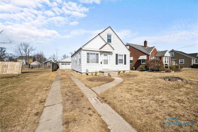 bungalow-style home with an outdoor structure and fence