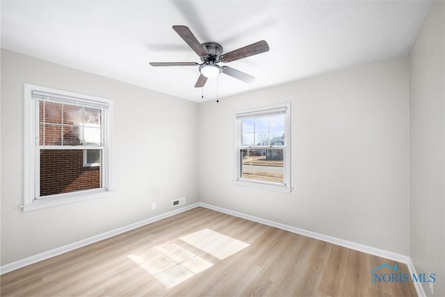 unfurnished room featuring visible vents, ceiling fan, light wood-type flooring, and baseboards