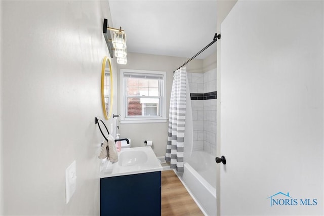 bathroom with shower / bathtub combination with curtain, vanity, and wood finished floors