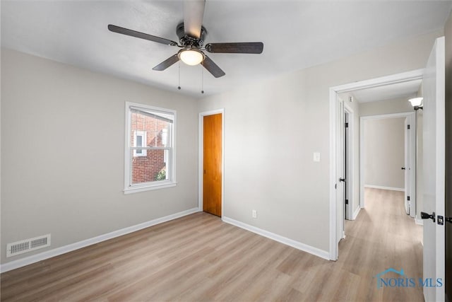 unfurnished bedroom featuring visible vents, ceiling fan, light wood-type flooring, and baseboards