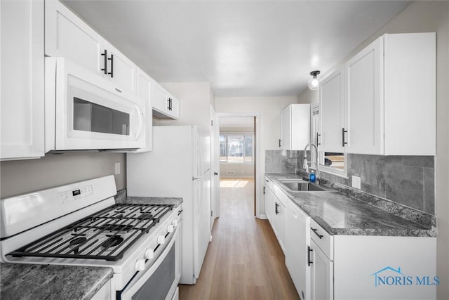 kitchen featuring a sink, tasteful backsplash, wood finished floors, white appliances, and white cabinets