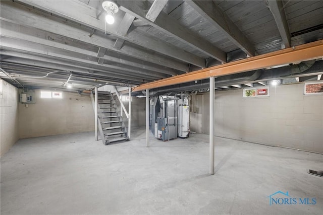 basement featuring heating unit, electric panel, water heater, and stairs