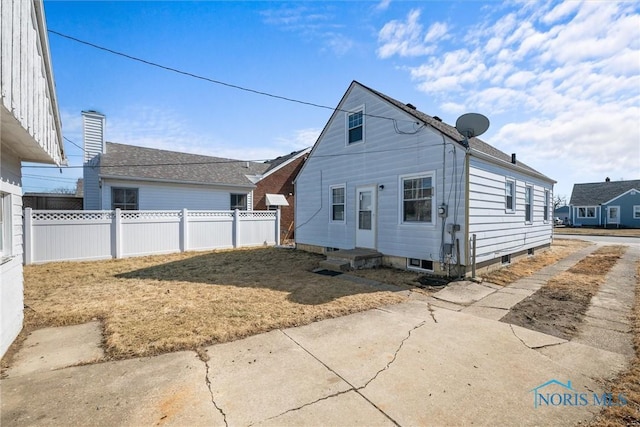 rear view of property featuring entry steps and fence