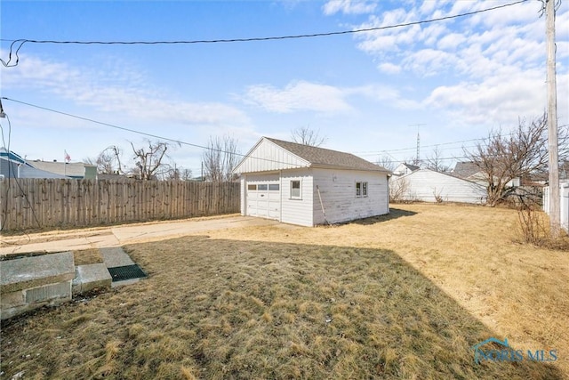 view of yard with an outdoor structure, fence, and a garage