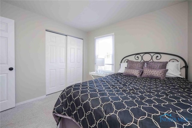 carpeted bedroom featuring a closet and baseboards