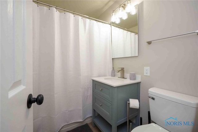 full bath featuring vanity, a shower with shower curtain, and toilet