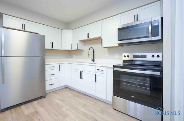 kitchen featuring a sink, white cabinetry, appliances with stainless steel finishes, and light countertops