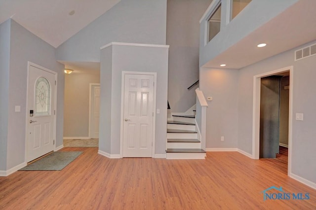 entryway featuring stairway, baseboards, light wood-style floors, and visible vents