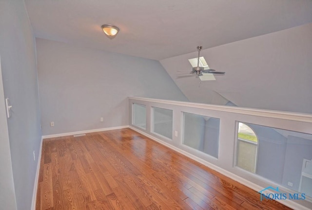 additional living space with ceiling fan, baseboards, lofted ceiling, and wood finished floors