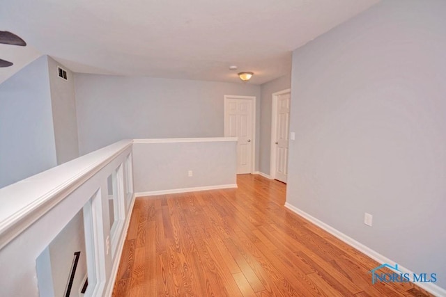 empty room with visible vents, baseboards, and light wood-style flooring