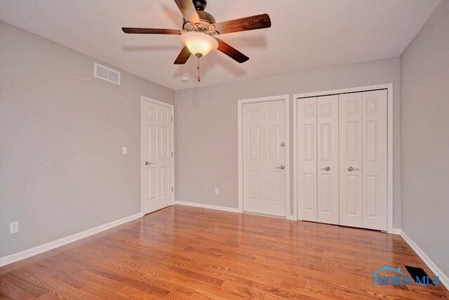 unfurnished bedroom with visible vents, baseboards, light wood-style floors, and a ceiling fan