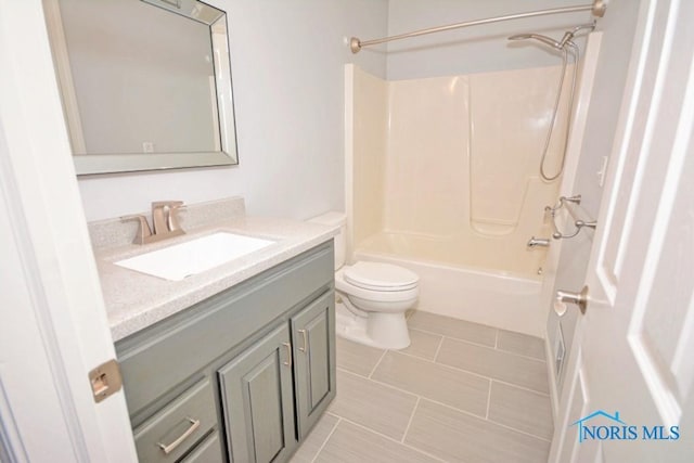 bathroom featuring vanity, bathing tub / shower combination, toilet, and tile patterned flooring