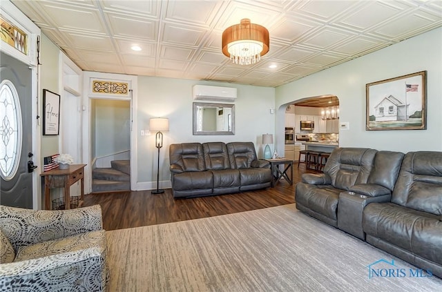 living room with stairs, a wall unit AC, arched walkways, and an ornate ceiling