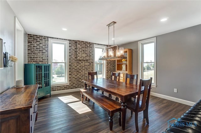 dining space with dark wood-style floors, recessed lighting, brick wall, and baseboards