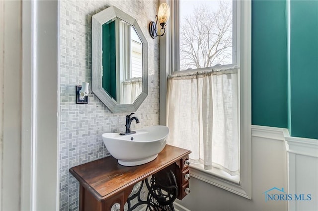 bathroom featuring a wainscoted wall and vanity