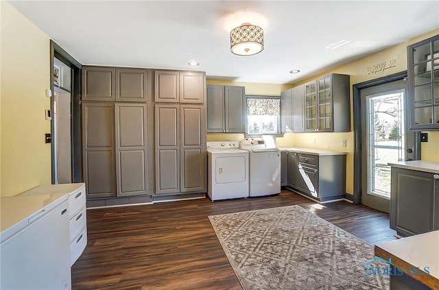 washroom featuring a wealth of natural light, recessed lighting, washer and dryer, and dark wood finished floors