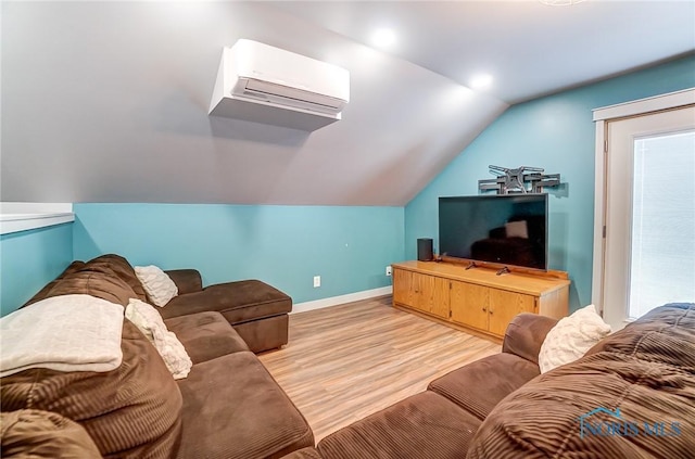 living area with vaulted ceiling, baseboards, light wood finished floors, and a wall mounted AC