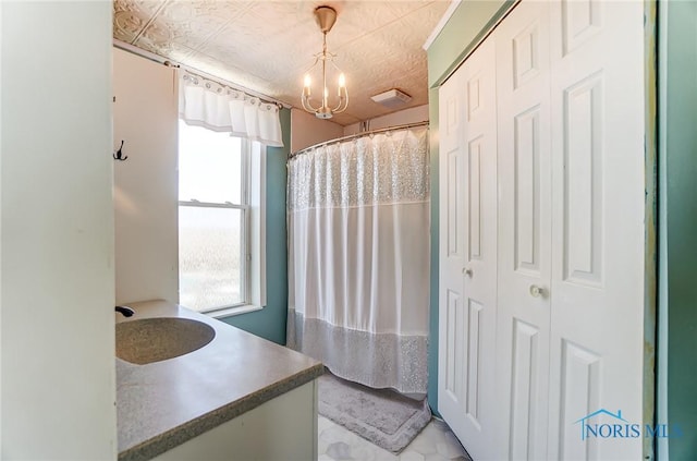 bathroom with curtained shower, a notable chandelier, and vanity