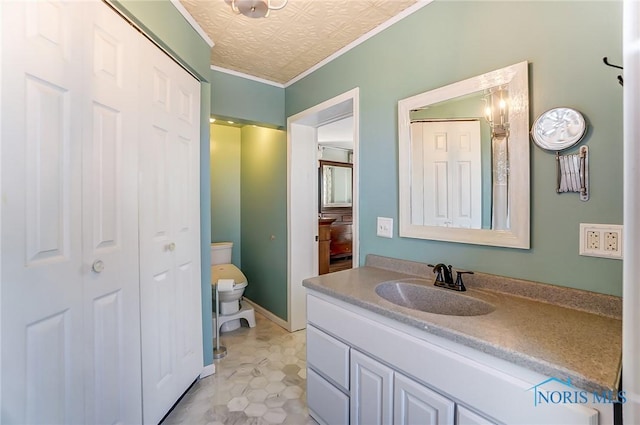 bathroom with crown molding, baseboards, toilet, an ornate ceiling, and vanity