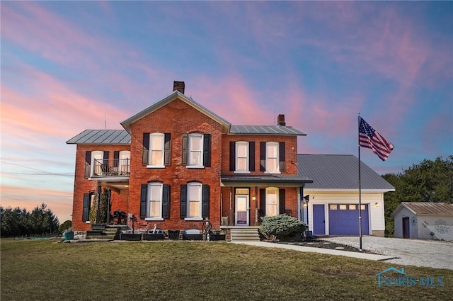 view of front of house with a balcony, brick siding, and a chimney