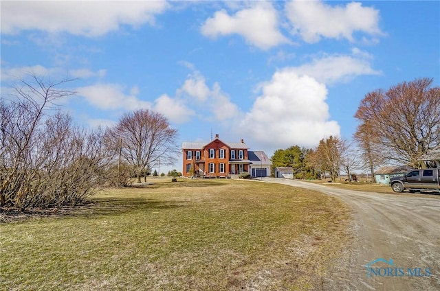 view of front facade with a front lawn, an attached garage, and driveway