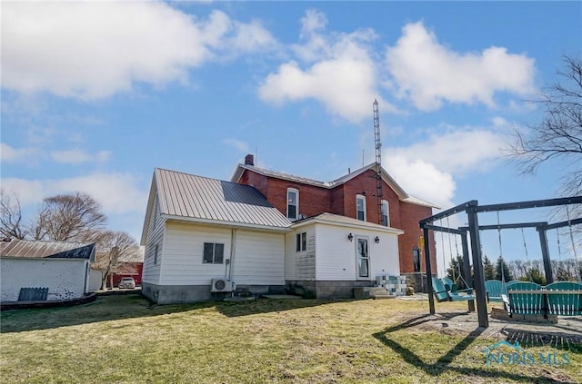 back of property with a lawn, metal roof, and ac unit