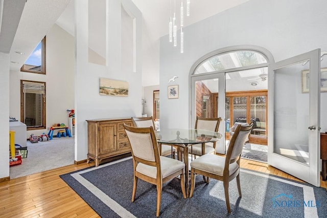 dining area featuring a high ceiling and hardwood / wood-style floors