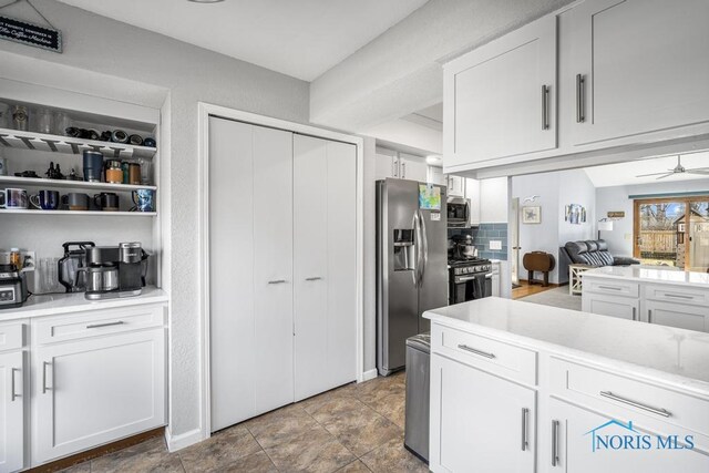 kitchen with white cabinets, stainless steel appliances, light countertops, and a ceiling fan