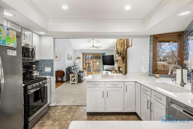 kitchen featuring open floor plan, a healthy amount of sunlight, stainless steel appliances, and a sink