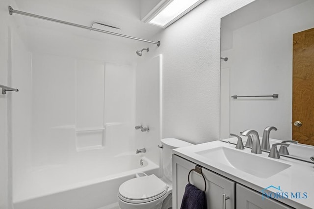 bathroom featuring toilet, vanity, and shower / tub combination