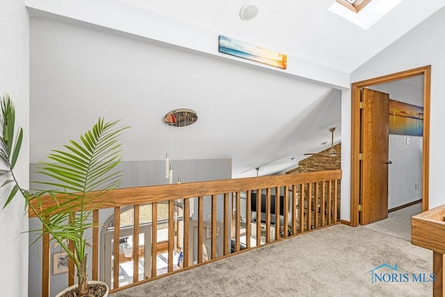 hall with lofted ceiling with skylight and carpet