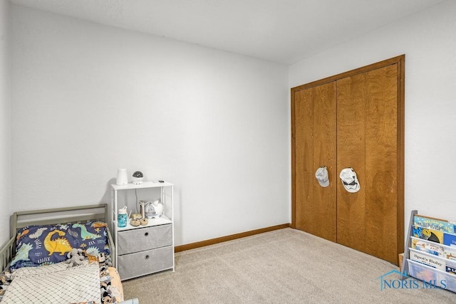 bedroom with a closet, baseboards, and carpet