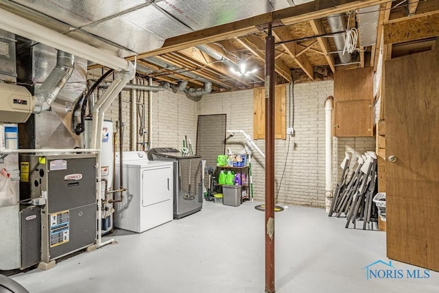 unfinished basement featuring gas water heater, heating unit, separate washer and dryer, and brick wall