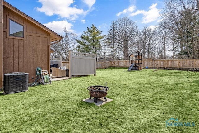 view of yard with cooling unit, a fire pit, a fenced backyard, and a playground